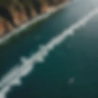 An aerial perspective of surfers using motorized foils in a scenic ocean landscape