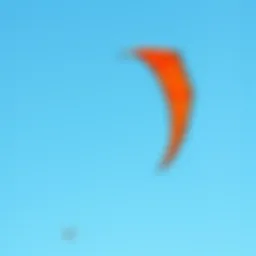 A vibrant duotone kite soaring against a clear blue sky