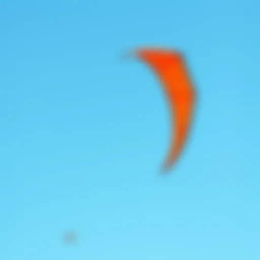 A vibrant duotone kite soaring against a clear blue sky