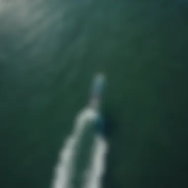 An aerial perspective of a kitesurfer gliding across the water with ease