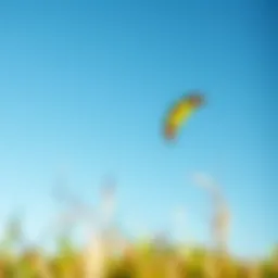 A vibrant kiteboarding kite soaring high against a clear blue sky
