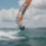 An aerial view of a hydrofoiling kiteboarder gliding over the water