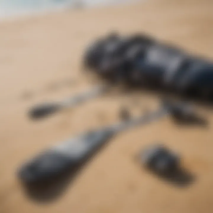 A detailed view of essential kite surfing gear laid out on the sandy beach.