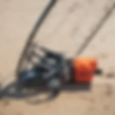 Close-up of essential kite surfing equipment laid out on the sand.