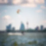 A kiteboarder gliding over the water with the city skyline in the background