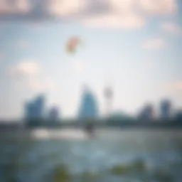 A kiteboarder gliding over the water with the city skyline in the background