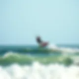 Kiteboarder gliding over ocean waves at Sagamore Beach