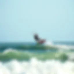 Kiteboarder gliding over ocean waves at Sagamore Beach