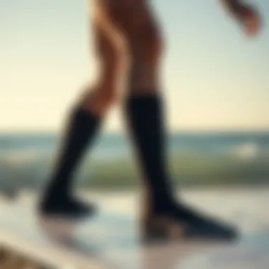 Surfer with Neoprene Socks A surfer wearing neoprene socks while standing on a surfboard in the ocean.