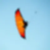 Agile Small Kite in Action A small kite soaring against a clear blue sky, demonstrating agility in kiteboarding.