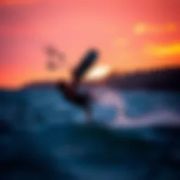 A kiteboarder executing a backroll maneuver against a vibrant sunset.