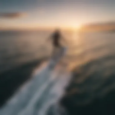 An aerial shot of a rider gliding above the water on a foilboard during sunset.